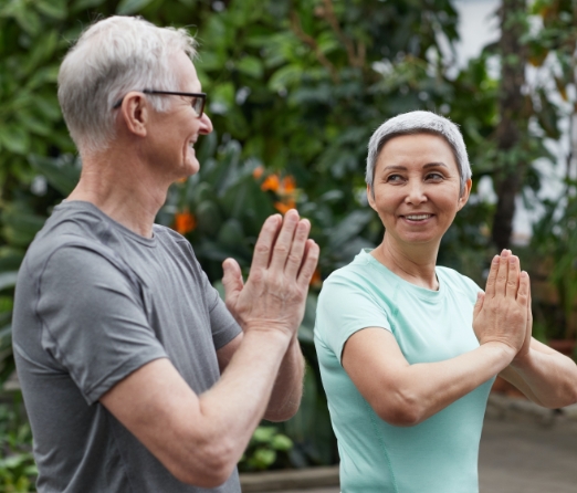 An older couple, practicing yoga in a serene garden for Emsella for Men