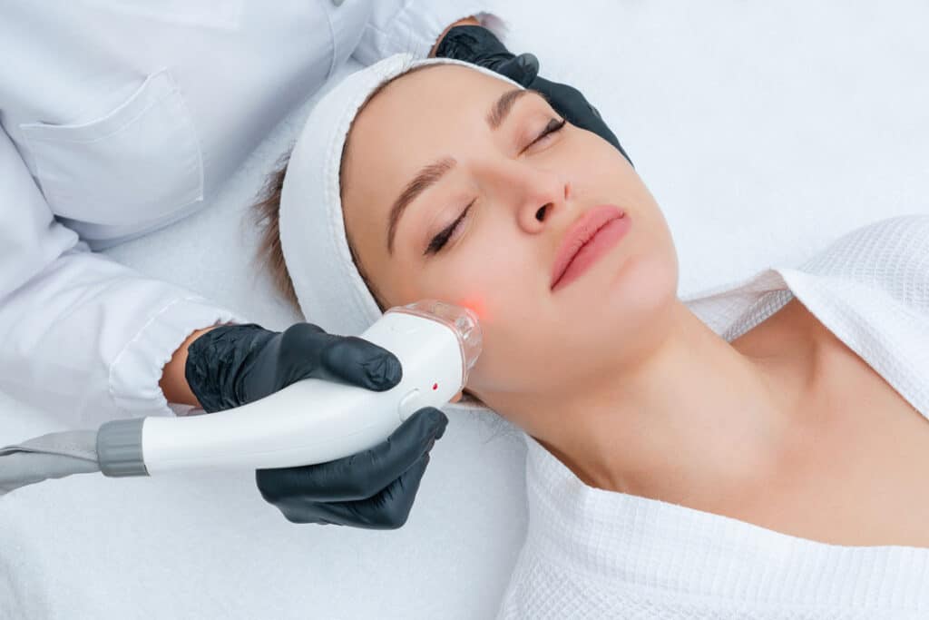 A woman undergoing a laser treatment at Ivee Restorative Care, showcasing advanced skincare technology in a serene environment.