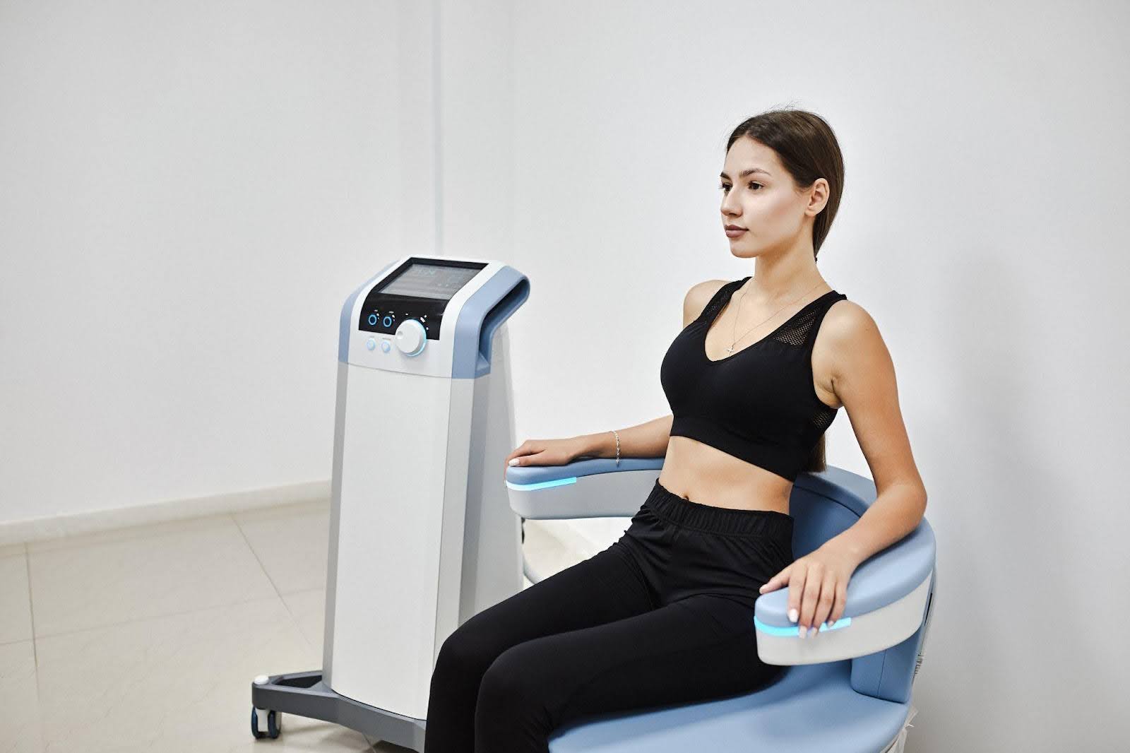 A woman seated on a chair focused on operating a machine in a well-lit environment