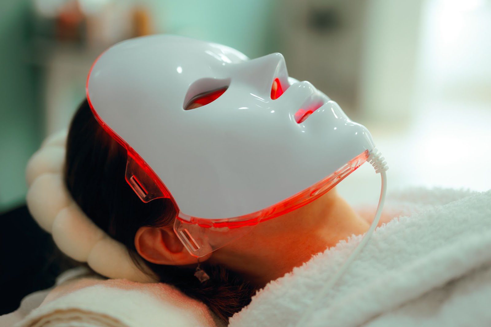 Person wearing a red light therapy mask while lying down.