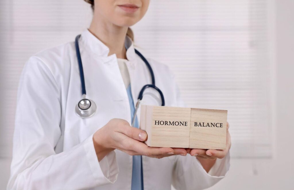 A female doctor holds a box labeled hormone balance smiling and promoting health and wellness