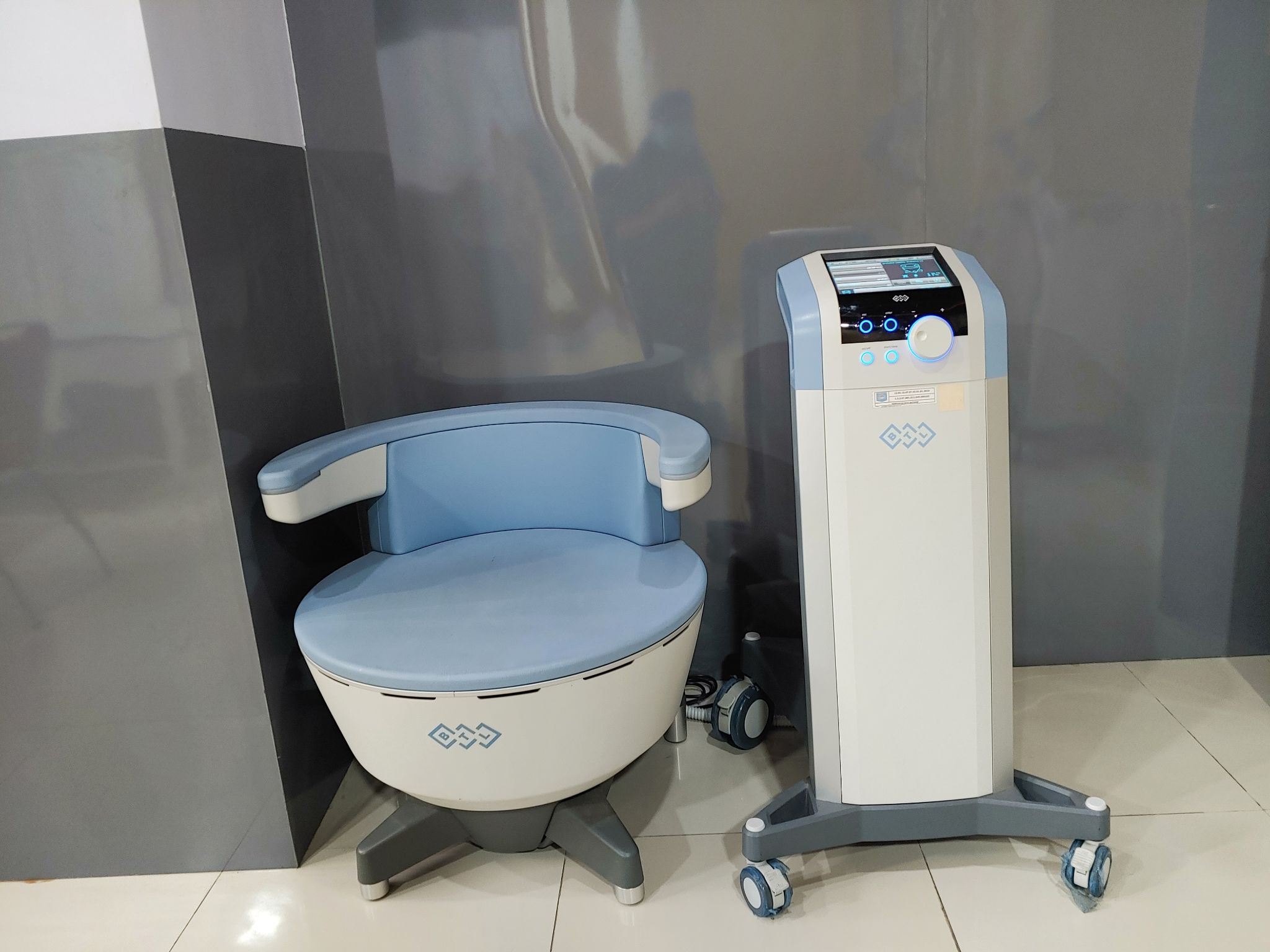 A BTL Emsella medical chair and console setup used for non-invasive pelvic floor therapy.
