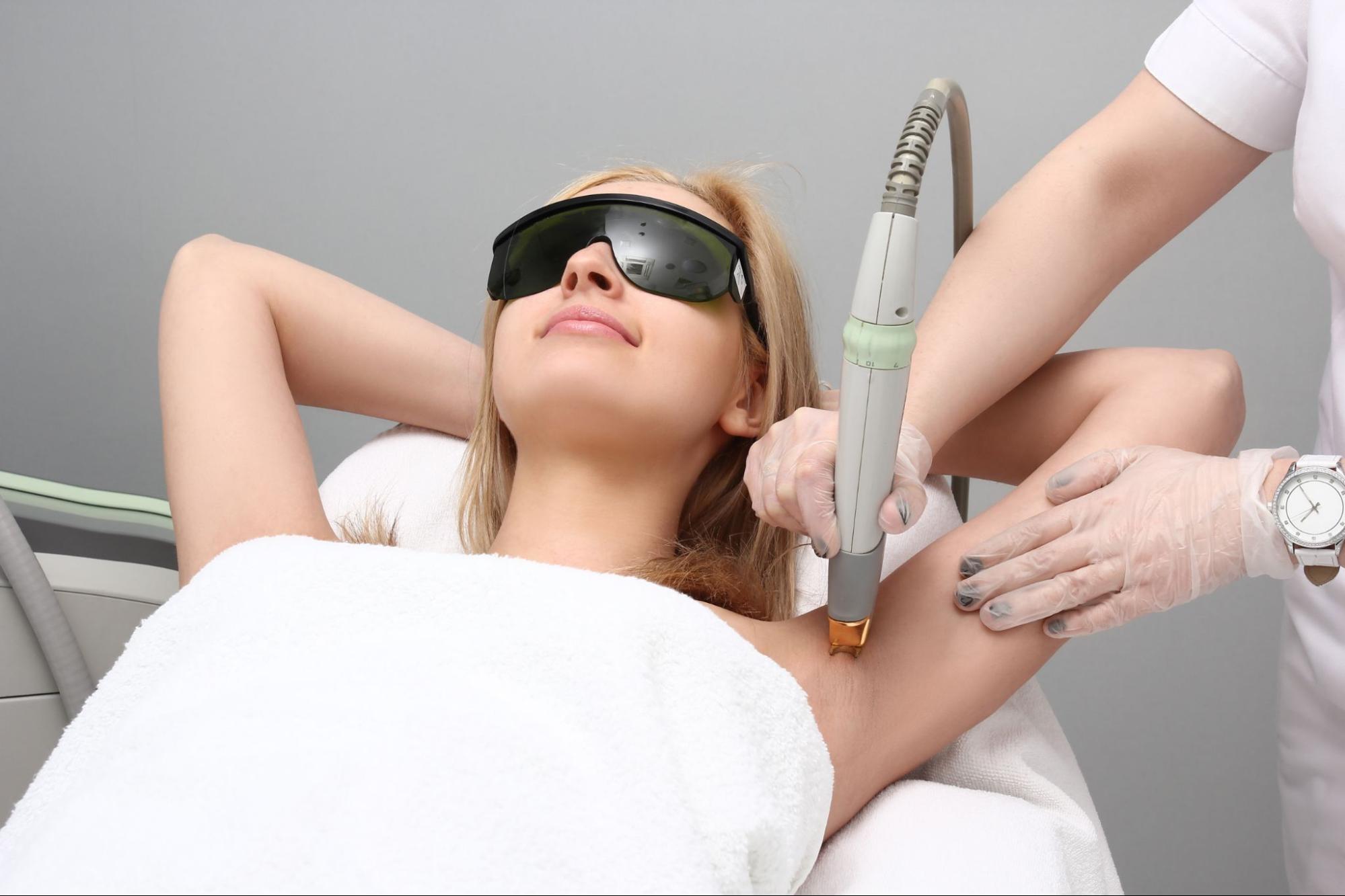 Patient wearing protective eyewear during an advanced laser hair removal treatment on the underarm area for safe and effective long-term hair reduction.